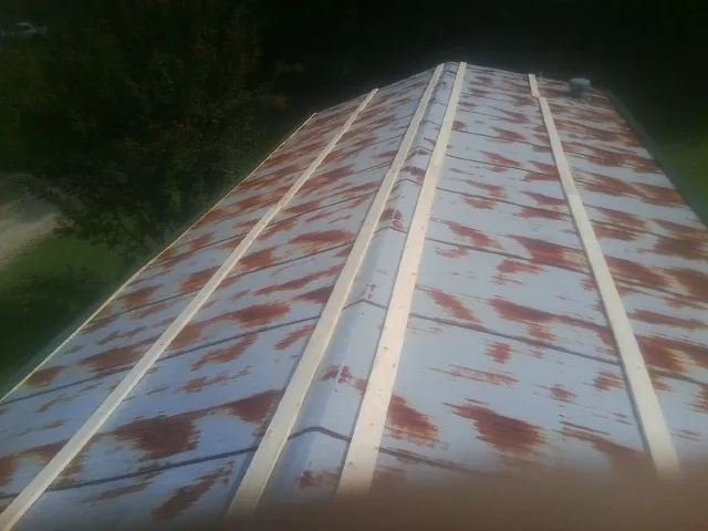 Rusted metal roof panels with new wood purlins before replacement — Storm Damage Roof Repair in Goldsmith by Roofing Brothers