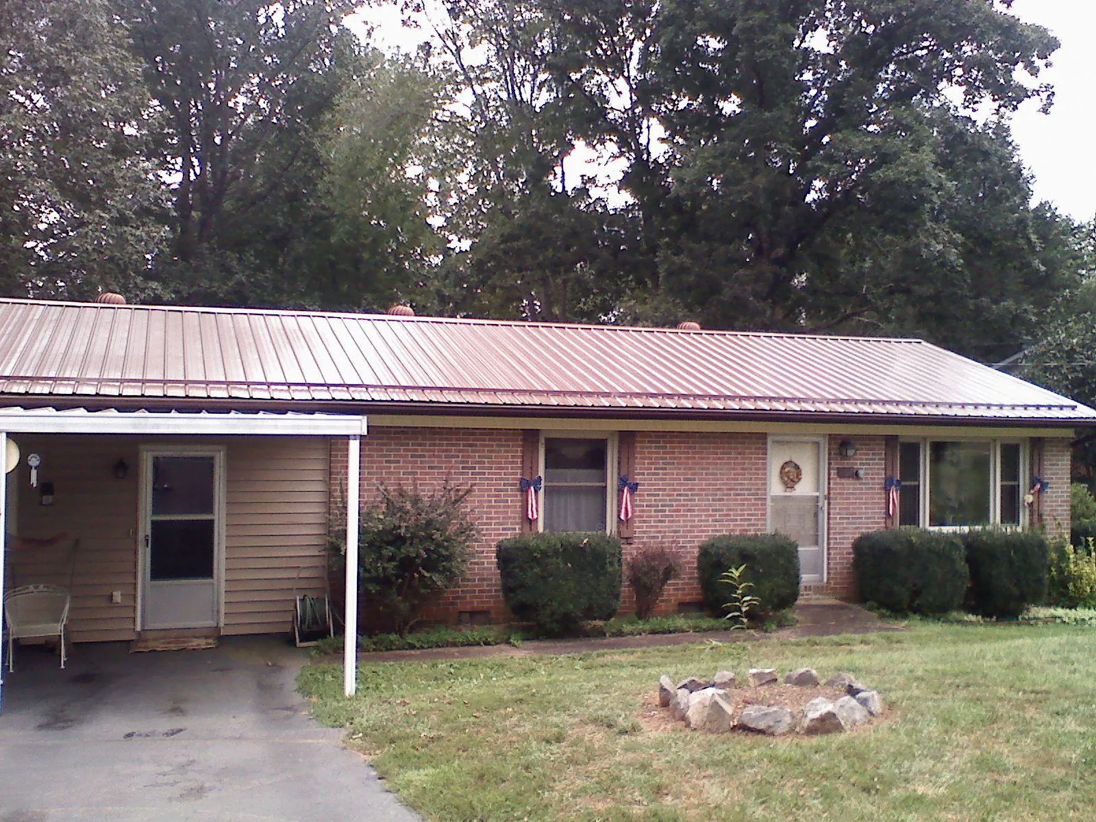 Bronze metal roof and carport on a brick ranch home — Roof Repair work by our crew in Goldsmith